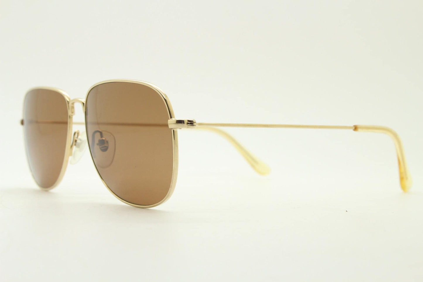 Helmut Lang rectangular 90s vintage sunglasses made in Japan. Minimal gold chrome frame with warm brown lenses. Luxury modified aviator