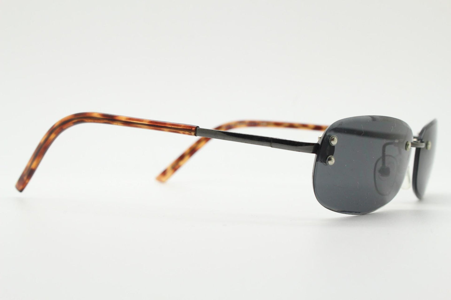 90s vintage minimal frameless sunglasses. Black rectangular lens with gunmetal grey trim and tortoise arms. Simple and effective design. NOS