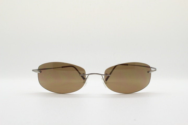 Faconnable 90s vintage sunglasses model 859 hand made in Italy. Minimal frameless design with flexible wire arms and brown chrome trim. NOS
