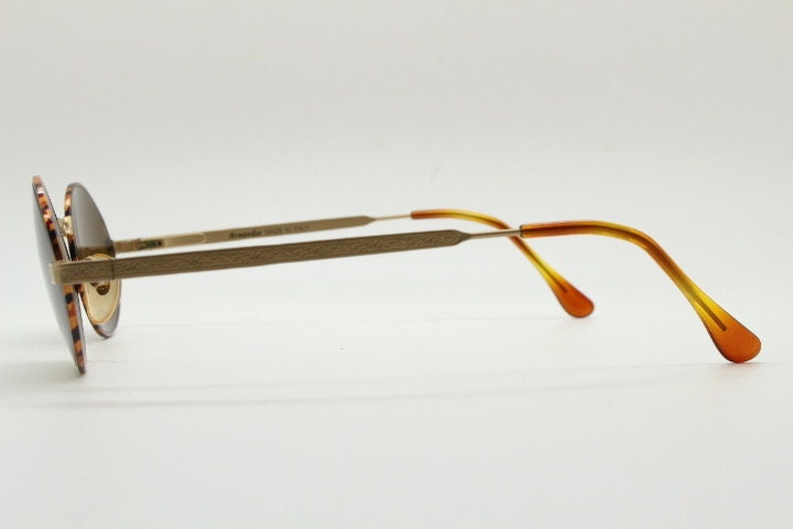Armandos 90s vintage oval sunglasses made in Italy. Enamelled honey tortoise front with ornate tooled metal arm patterns. NOS
