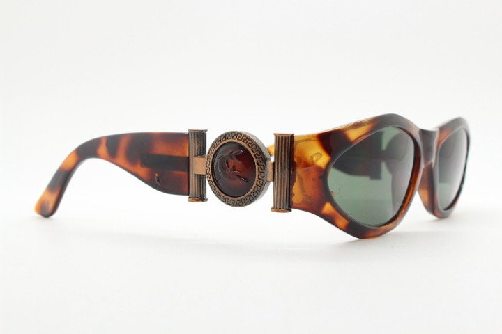 90s vintage oval sunglasses. Low profile transparent tortoise frame with massive bronze metal arm crests BNWT. Unused NOS