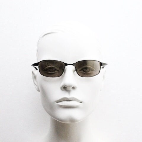 90s vintage curved rectangular sunglasses. Solid metal low profile frame in brown chrome with slightly mirrored lenses. 2000's. Y2K NOS