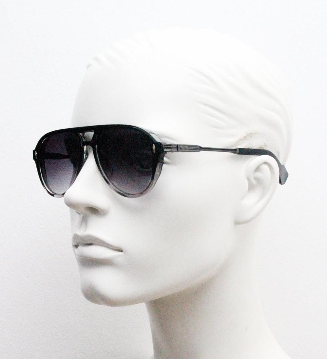 Y2K vintage transparent black aviator sunglasses. Well proportioned teardrop shape with graduating lenses and grey metal embossed arms. NOS