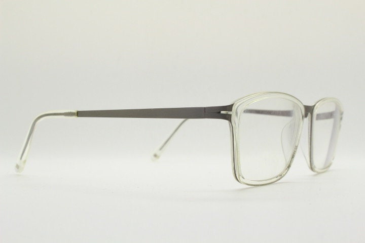 Modo rectangular eye glasses made in Japan. Matt grey titanium optical frame encasing transparent crystal acetate front. Prescription RX