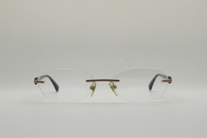 Vogue vintage frameless oval eye glasses. Transparent acetate arms with purple and green tones. Minimal Prescription RX Optical frame