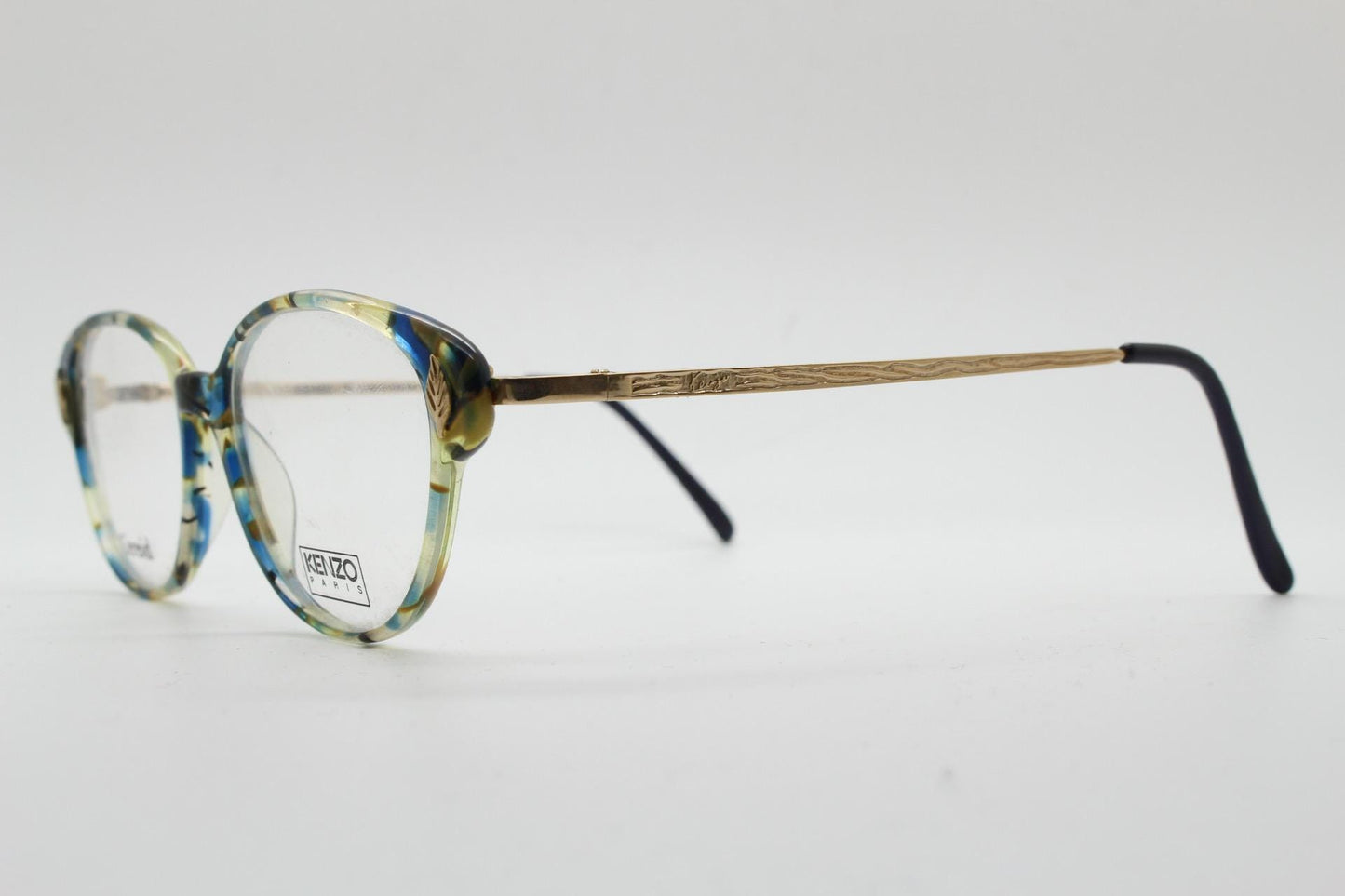 Kenzo 90s vintage cat eye glasses hand made in France. Transparent patterned optical frame with ornate arm details. Womens Prescription. NOS