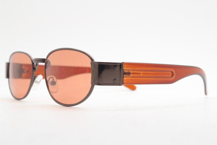 90s vintage low profile sunglasses. Brown chrome frame with thick transparent amber arms and orange lenses. Unused. BNWT