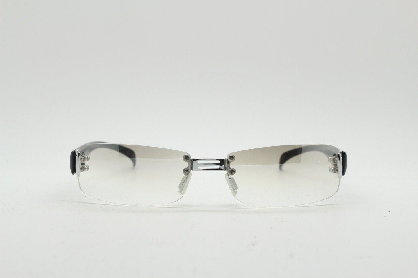 Y2K vintage frameless sunglasses. Silver chrome trim with patterned arms and extra light tone graduated curved mirror lenses. 2000's. 90s
