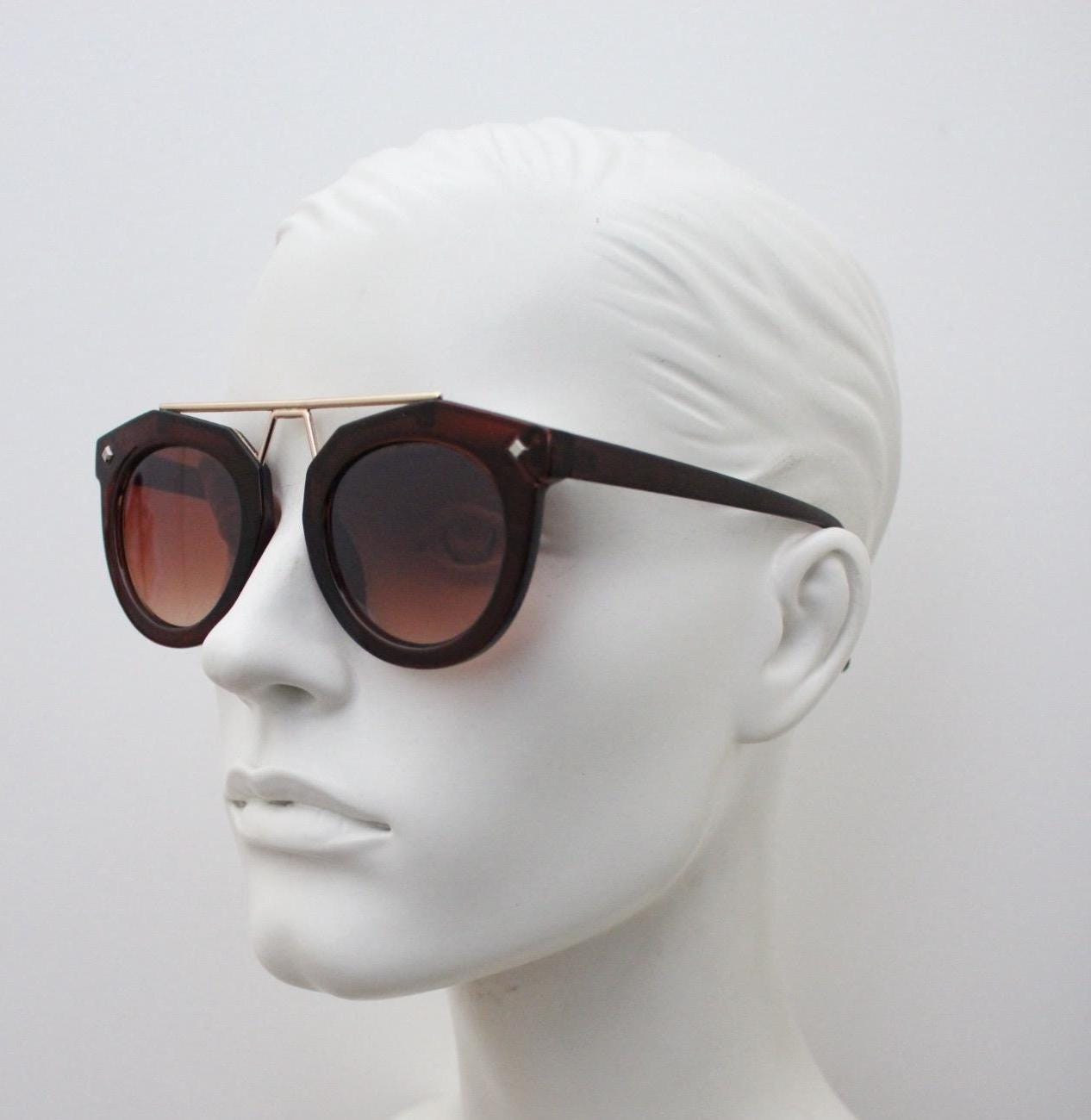 Rounded cateye sunglasses with gold 'scaffold' metal bridge. Women's transparent frame with matching brown graduating lenses. Vintage NOS