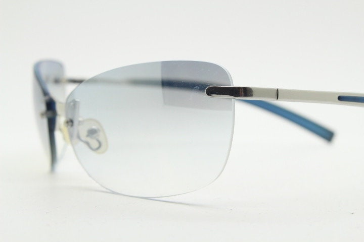 Y2K vintage wraparound sunglasses. Low profile frameless design in black matt finish with light tone graduated mirror lenses. 2000's. NOS