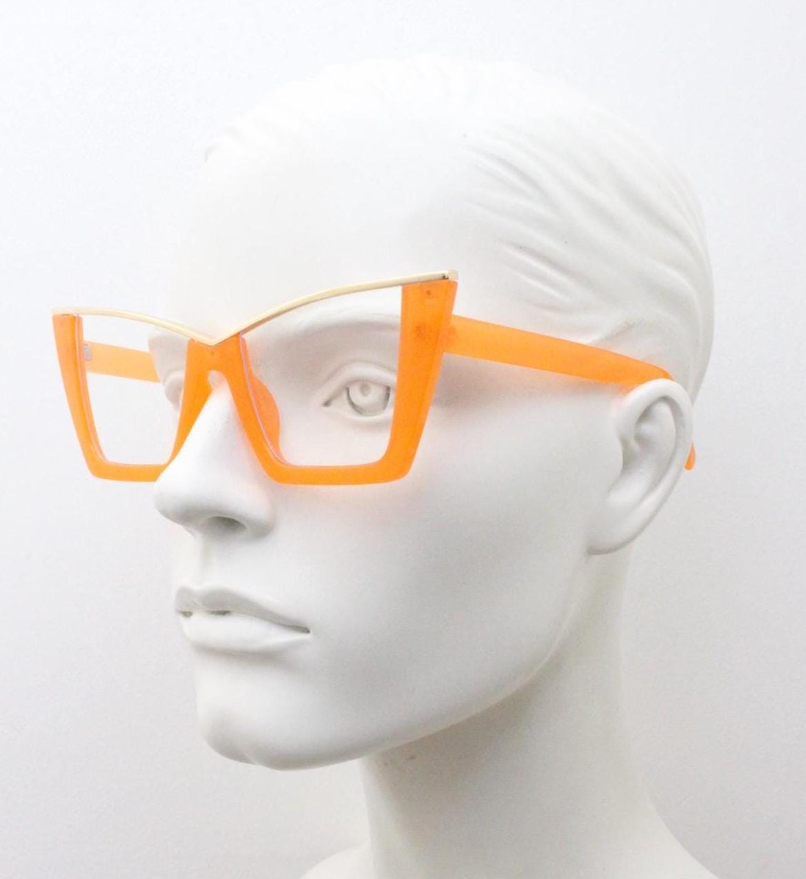Dynamic pointed cat eye glasses. Transparent thick orange optical frame with gold metal 'owl' brow. and clear lenses. Vintage. Prescription