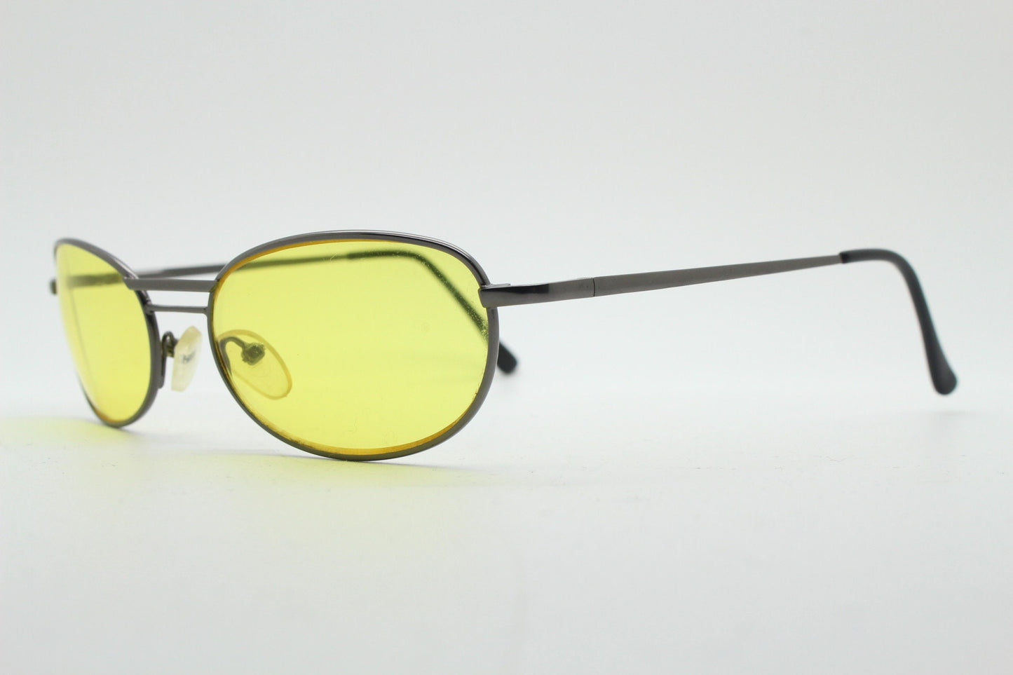 Y2K vintage small oval bug eye sunglasses. Gunmetal grey satin finish frame with blazing canary yellow lenses. Unused 2000s NOS. 90s micro