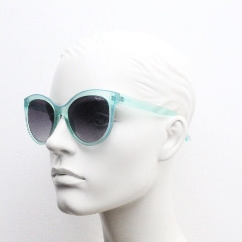 Pepe Jeans big cat eye sunglasses. Transparent chunky aquamarine frame with contrasting black graduating lenses. Womens vintage cateye