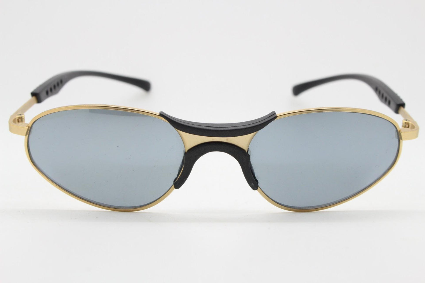 90s vintage oval small bug eye sunglasses. Curved gold satin finish metal frame with black matt trim and adjustable arm length. Unused NOS