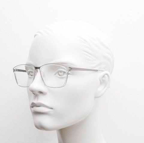 Modo rectangular eye glasses made in Japan. Matt grey titanium optical frame encasing transparent crystal acetate front. Prescription RX