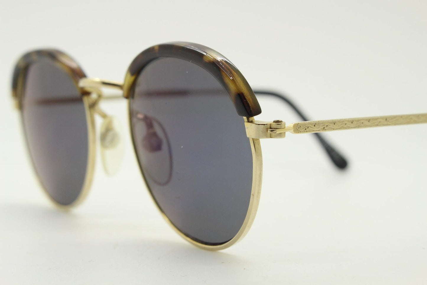 90s round vintage sunglasses. Gold frame with tortoise brows, blue mirror lenses and intricate embossed arm patterns. 1930's style