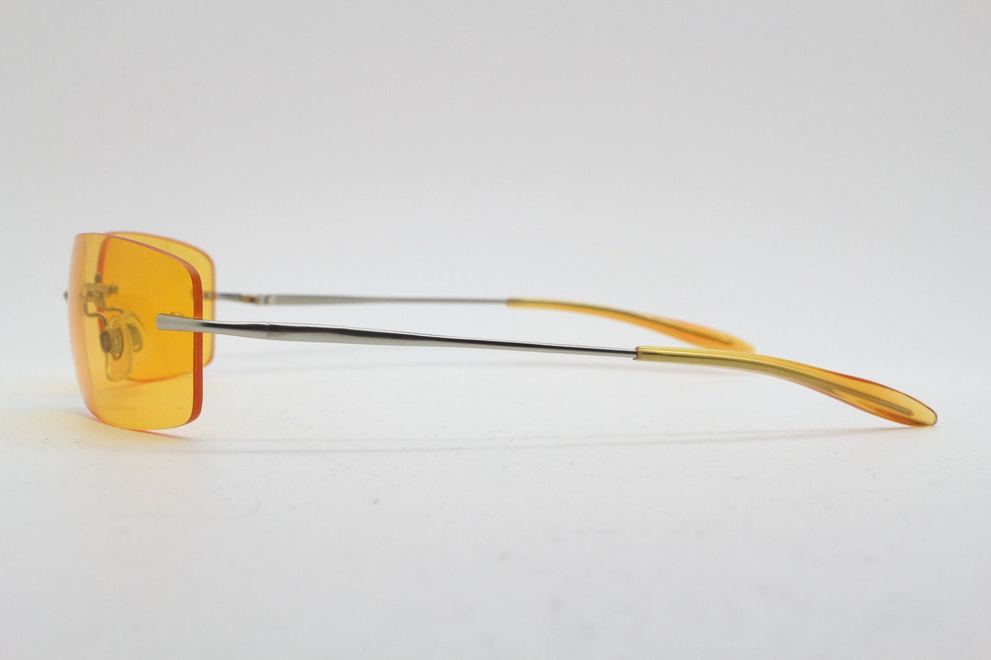 Y2K vintage frameless orange sunglasses. Rectangular wrap around lenses with satin silver bridge and arms. 2000s club kids. 00's. 90s. NOS