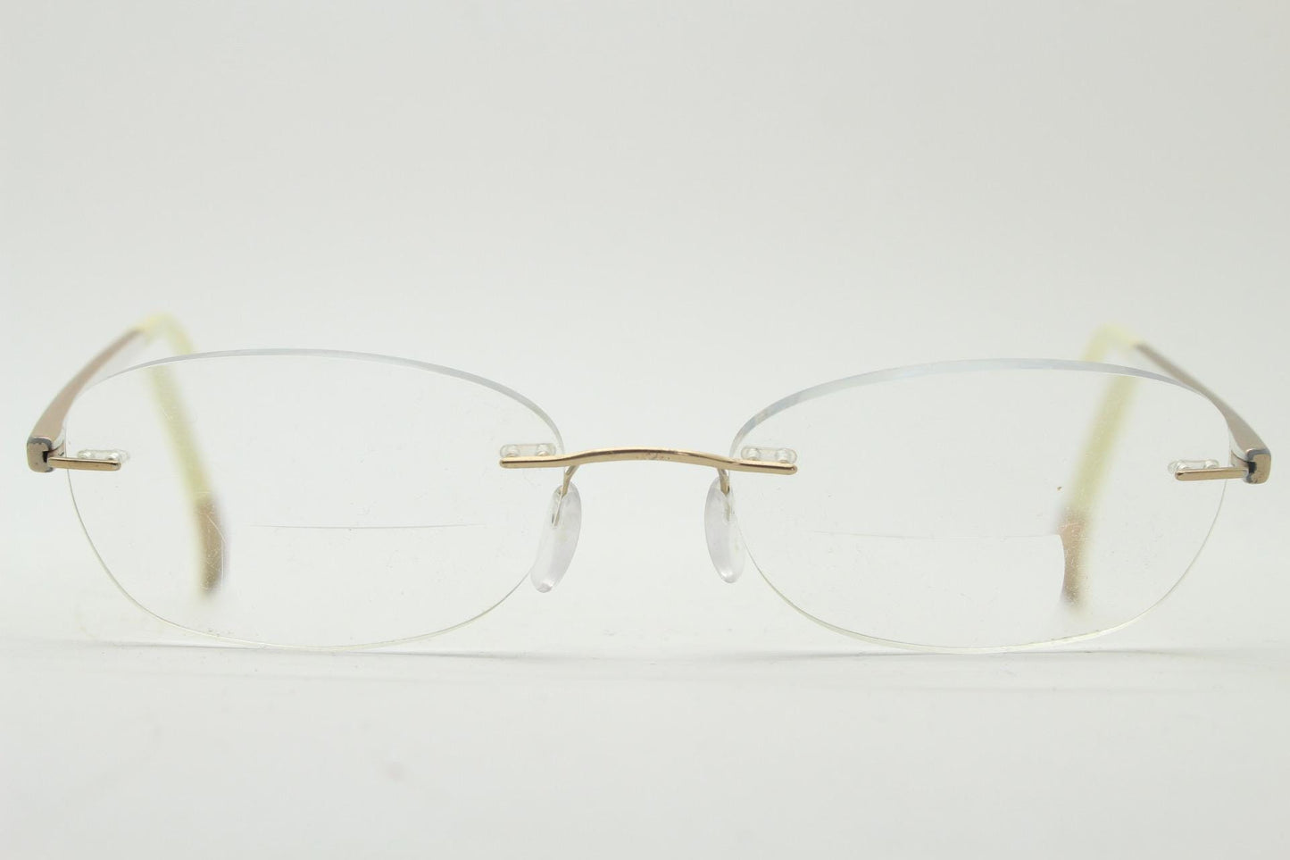 Silhouette rectangular frameless eye glasses made in Austria. Minimal lightweight gold with white enamel frame. 90s vintage. Prescription RX
