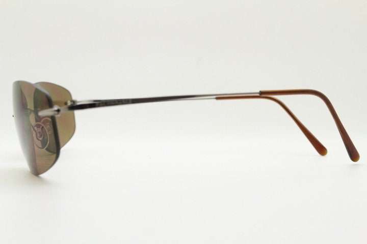 Faconnable 90s vintage sunglasses model 859 hand made in Italy. Minimal frameless design with flexible wire arms and brown chrome trim. NOS