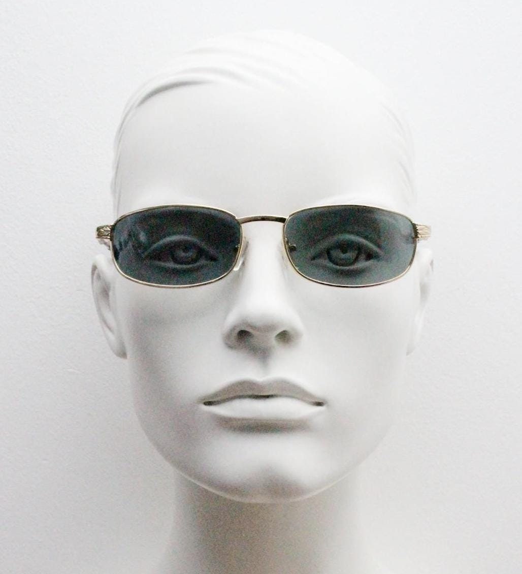 90s vintage low profile gold rectangular sunglasses. Solid metal frame in a shiny chrome finish embossed arm pattern and green lenses. NOS