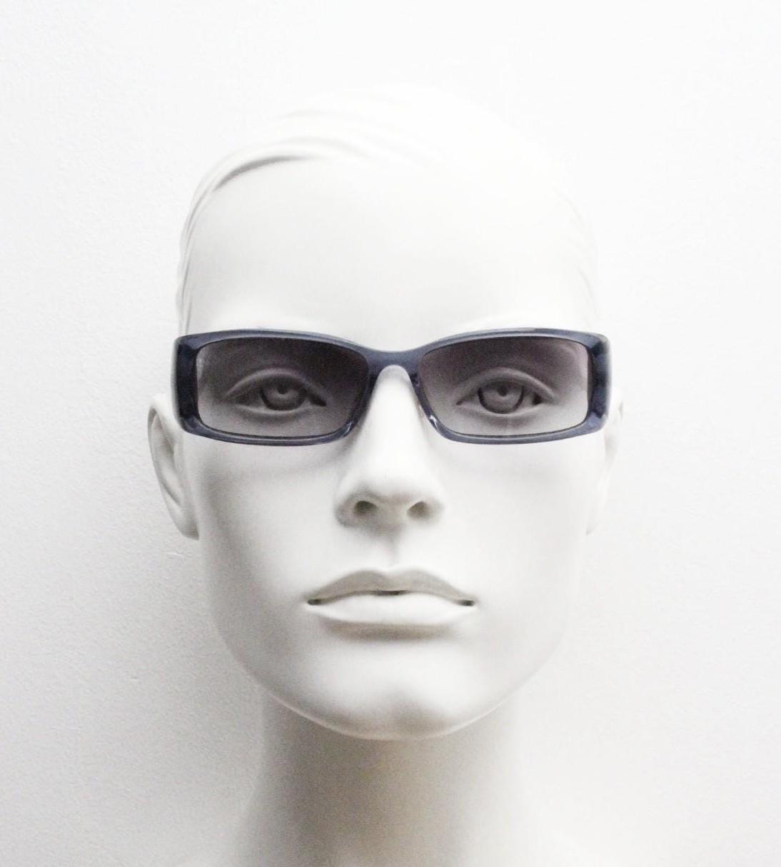 90s vintage rectangular low profile sunglasses by Storm. Transparent grey acetate front with brushed steel arms. NOS. 2000s