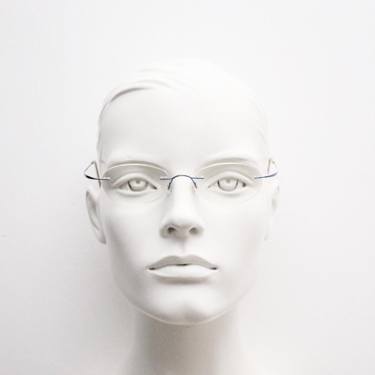 Frameless vintage oval eye glasses. Extremely minimal lightweight blue titanium optical frame with springy hingeless arms. 2000s