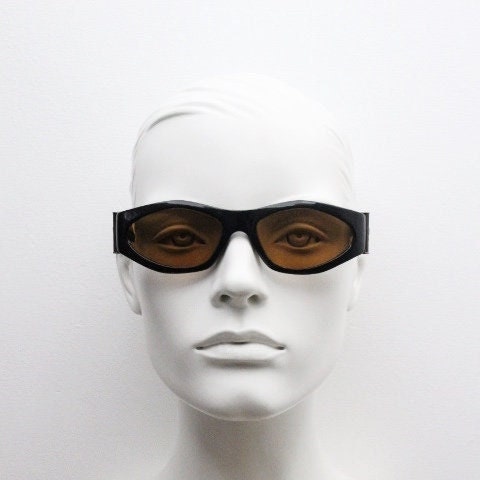 90s vintage oval sunglasses. Low profile black gloss frame with massive bronze metal arm crests and brown lenses. BNWT. Unworn NOS