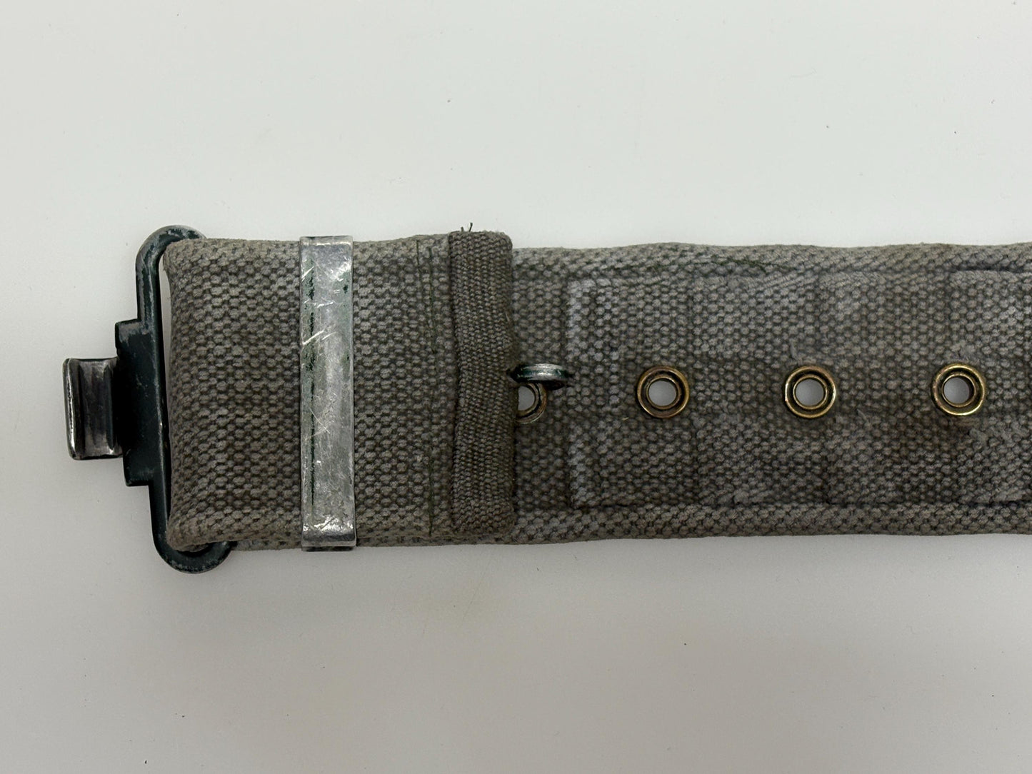 80s vintage real army webbing belt. Thick woven canvas in khaki green. Distressed look. Metal hardware. Fully adjustable. Tactical webbing