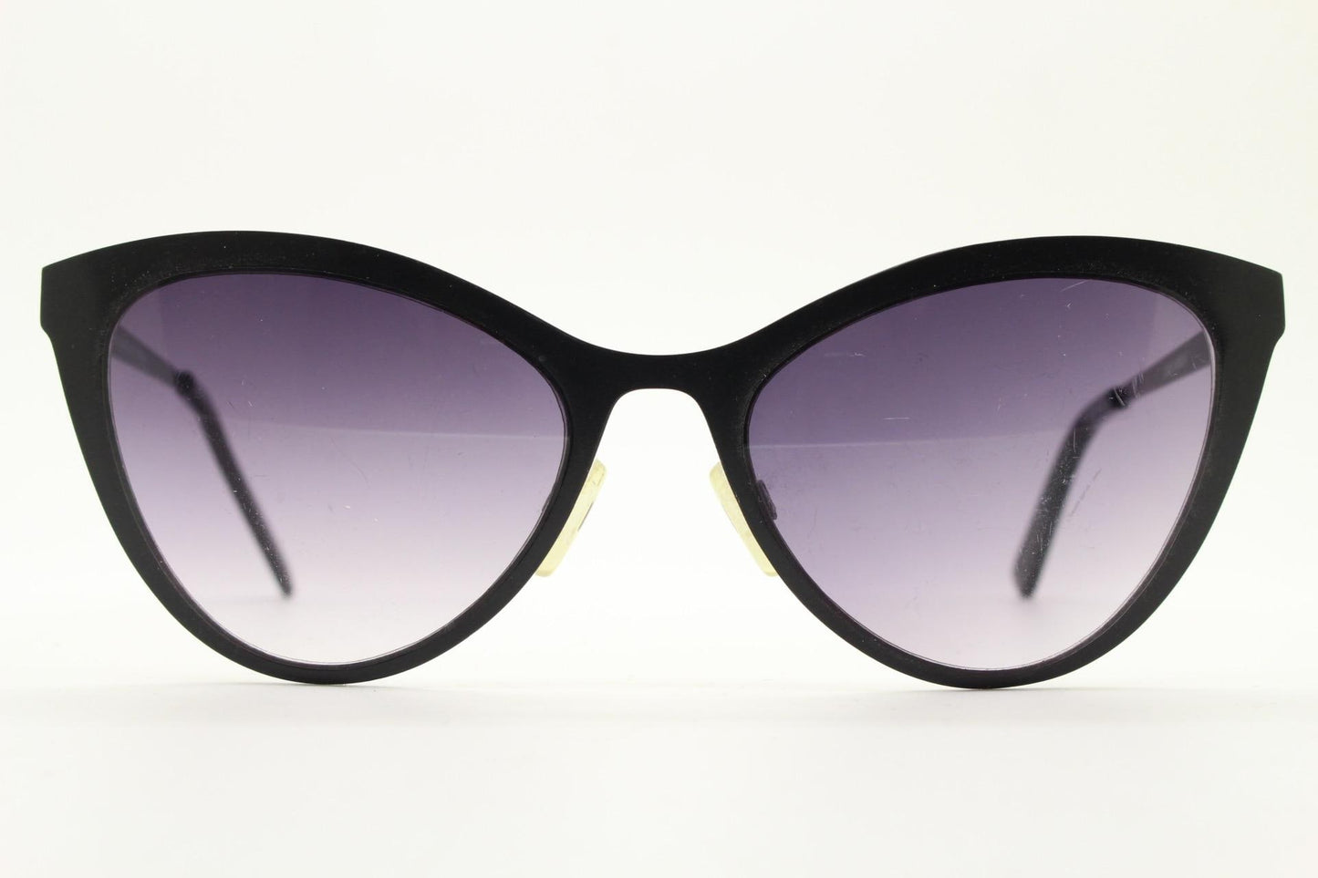 Vintage pointed cat eye sunglasses. Flat metal frame in a satin finish encasing smoky grey graduating lenses. Womens cateye