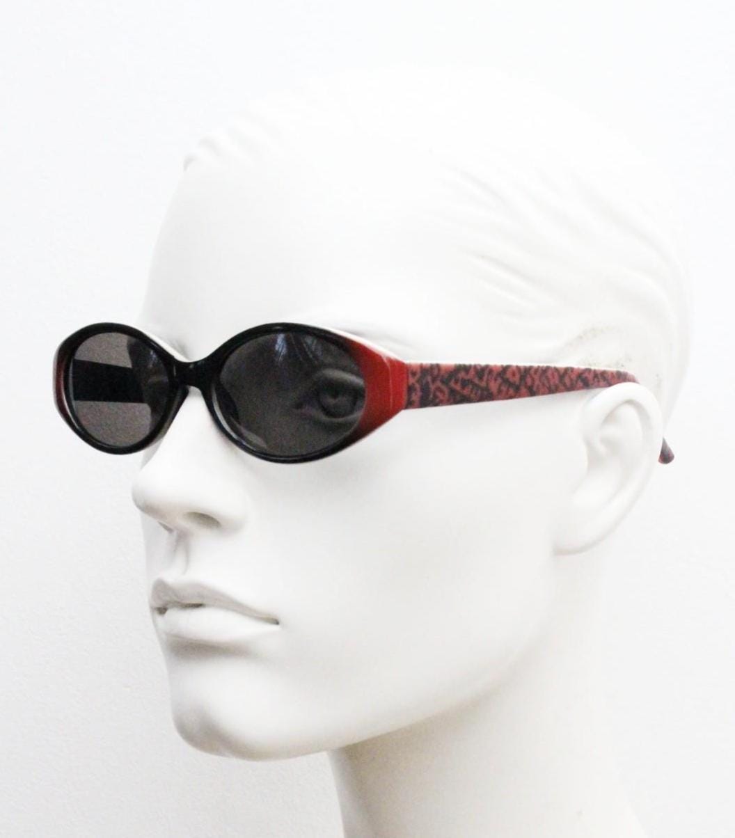 Vintage 90s oval sunglasses with very unique abstract arm pattern in black and red on layered acetate. Authentic original design. NOS