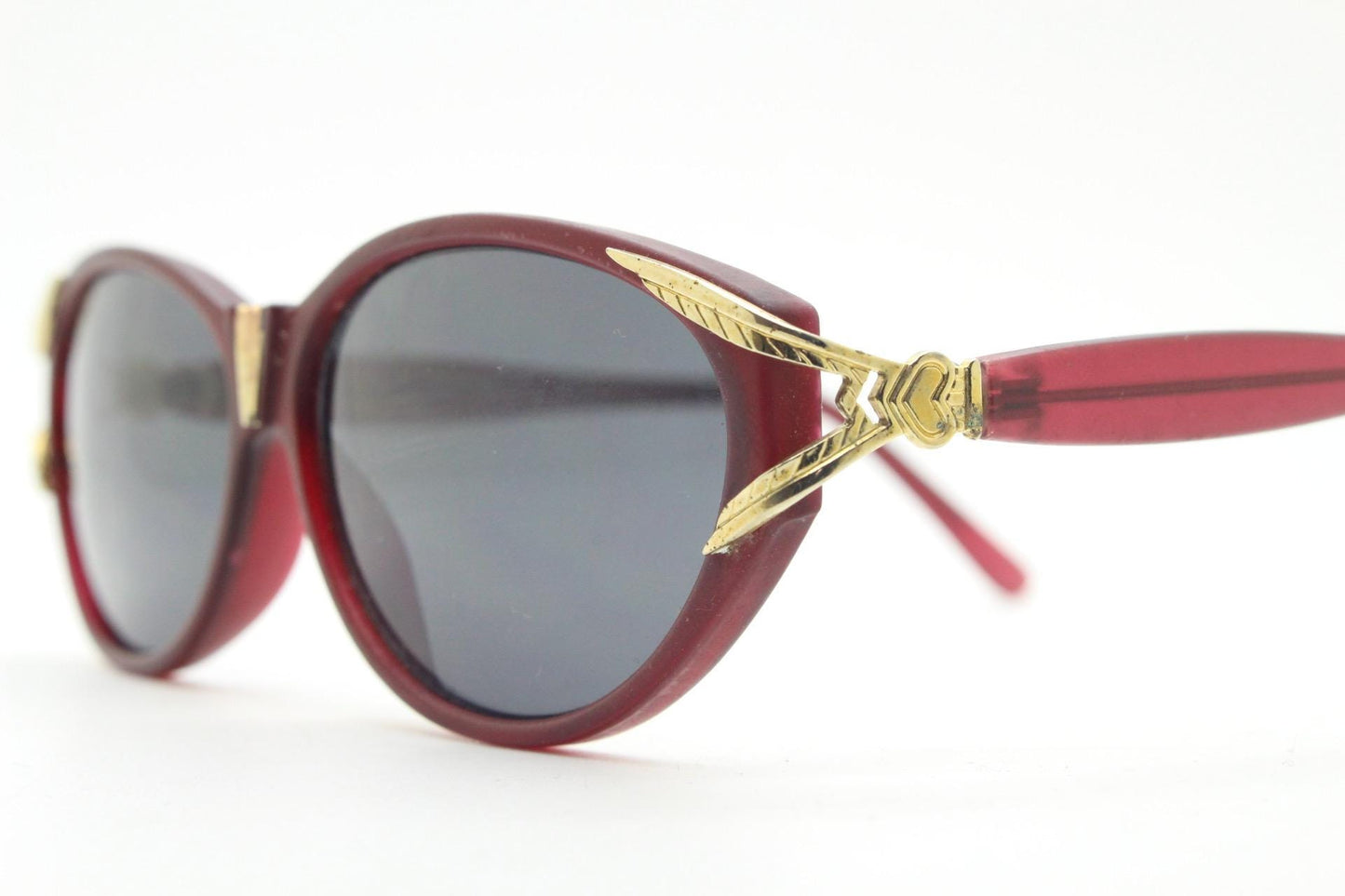 80s vintage Revlon cat eye sunglasses. Women's dark pink transparent frosted frame with golden Y fork ornate temples. 90s cateye. NOS