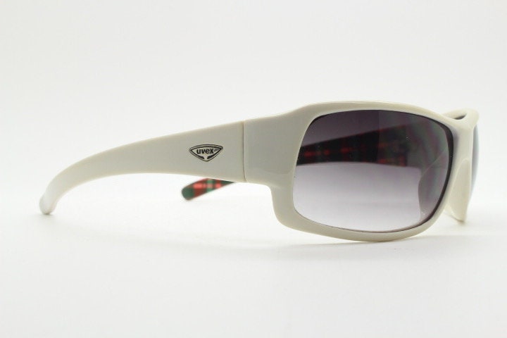 Uvex Y2k vintage wrap around bug eye sunglasses. Curving white sports shield frame with black lenses and tartan interior. Rave 2000s. NOS