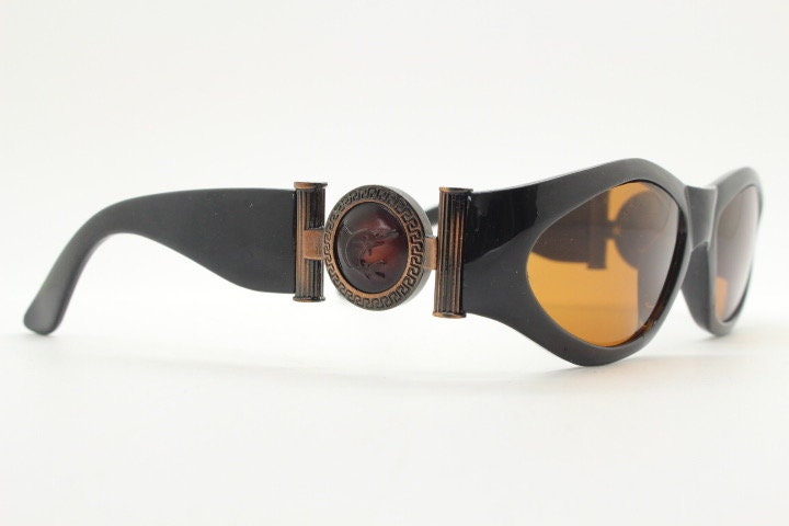 90s vintage oval sunglasses. Low profile black gloss frame with massive bronze metal arm crests and brown lenses. BNWT. Unworn NOS
