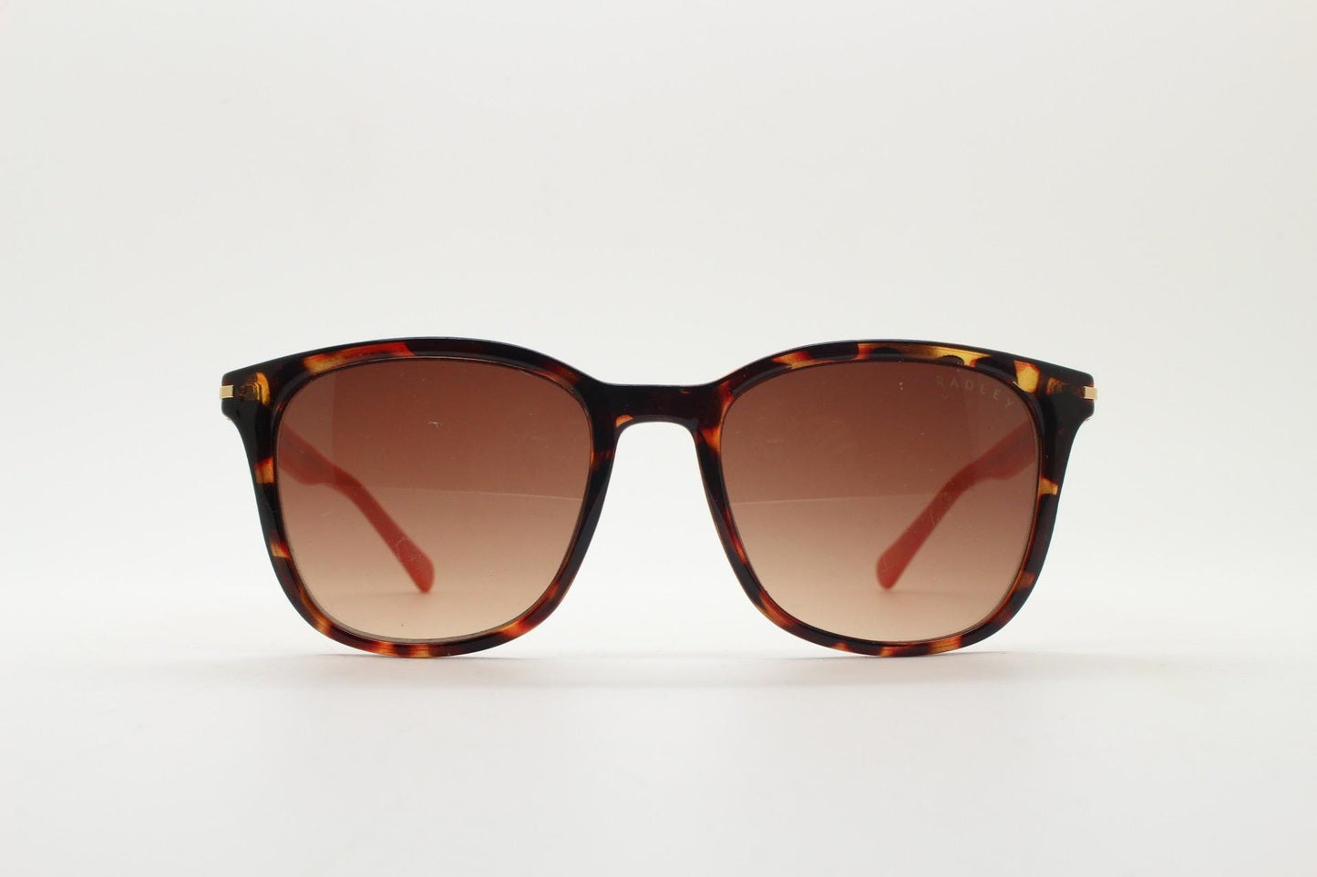Modified wayfarer design sunglasses by Radley. Tortoise front with bright orange arms and Havana brown lenses. Vintage. Unused NOS