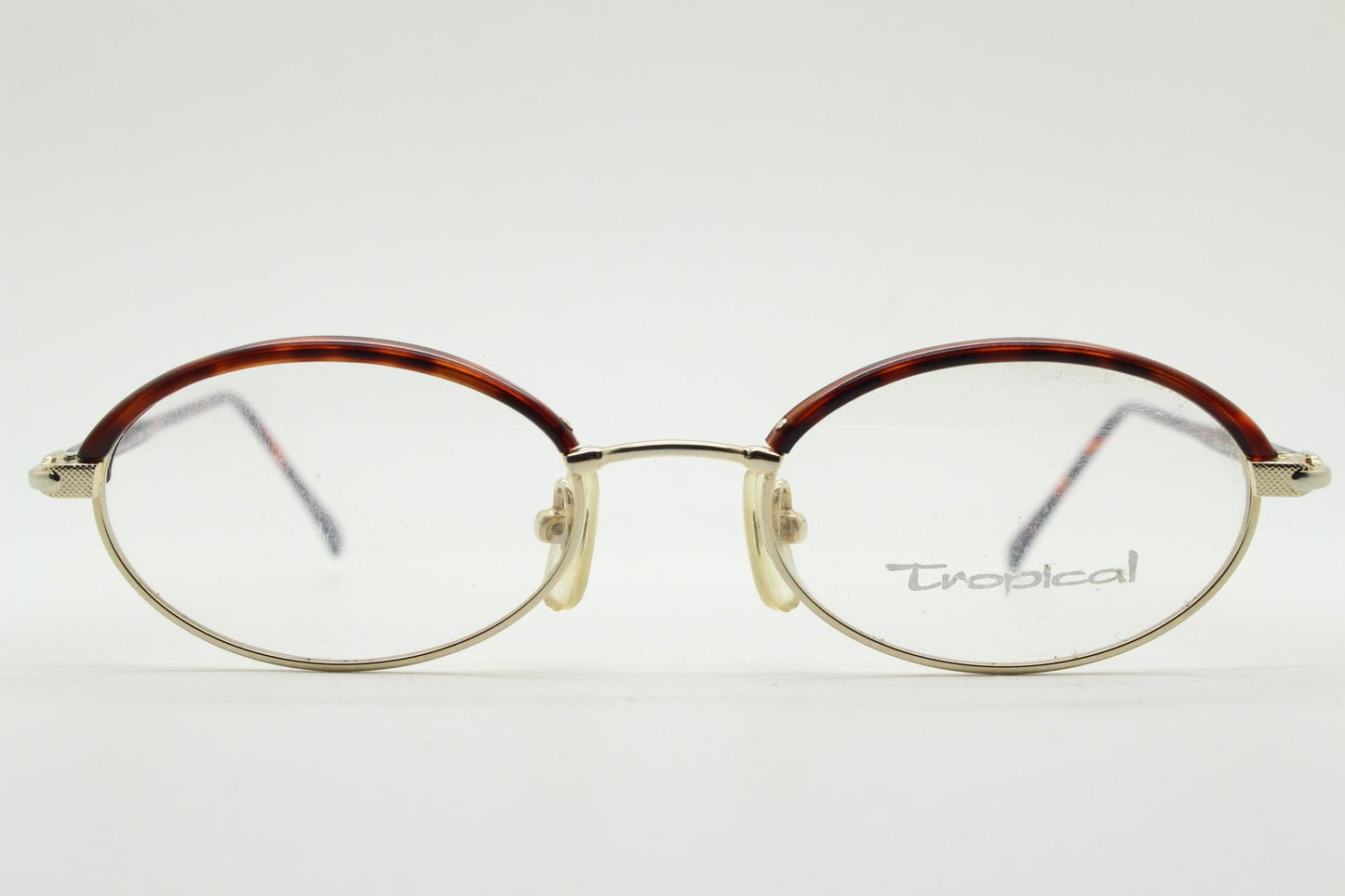 90s vintage small oval eye glasses by Tropical. Minimal gold optical frames with tortoise arms and brows. Prescription RX spectacles. NOS