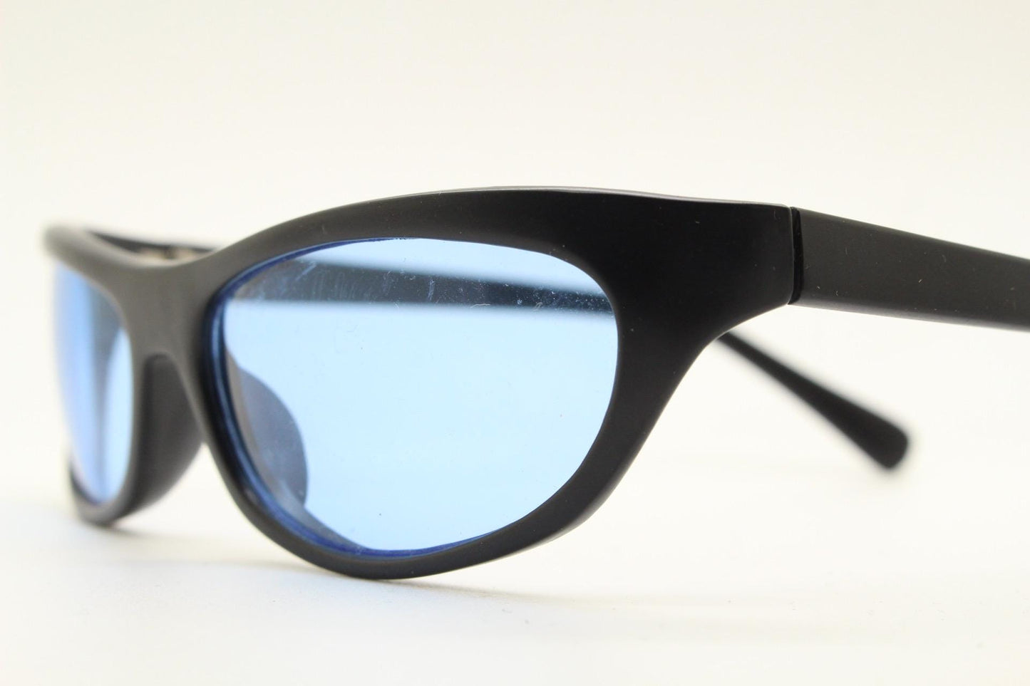 90s vintage curved wraparound sunglasses. Aerodynamic low profile black satin finish frame with light tone blue lenses. Sports shield. NOS