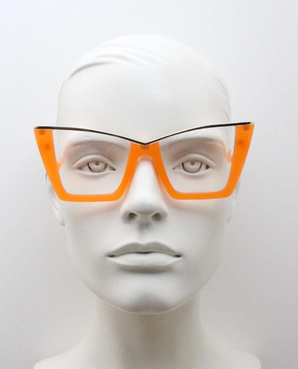 Dynamic pointed cat eye glasses. Transparent thick orange optical frame with gold metal 'owl' brow. and clear lenses. Vintage. Prescription