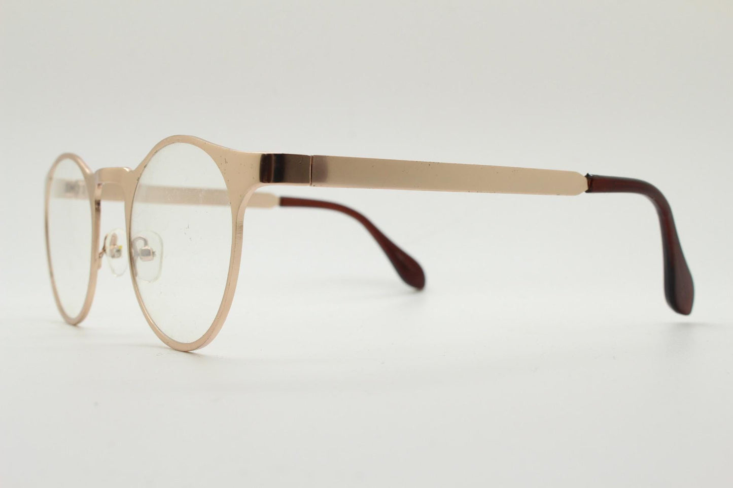 Y2K round metal eye glasses with pointed corners. Solid flat shiny golden frame with clear lenses.