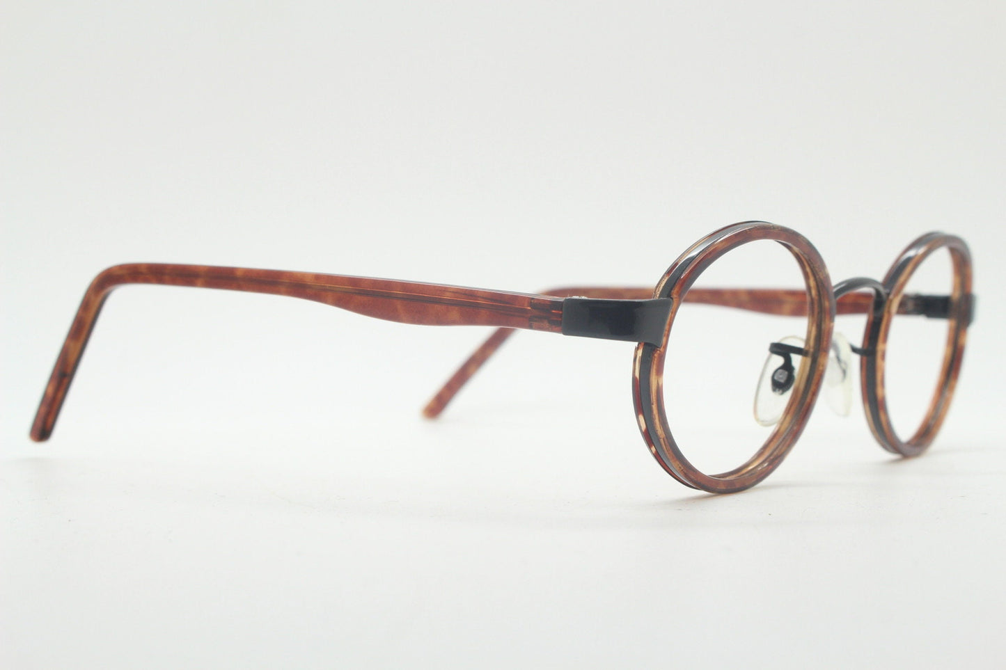 90s vintage oval glasses. Minimal slim black optical frame encasing tortoise inserts. 40s, 50s style prescription eyeglasses. RX spectacles