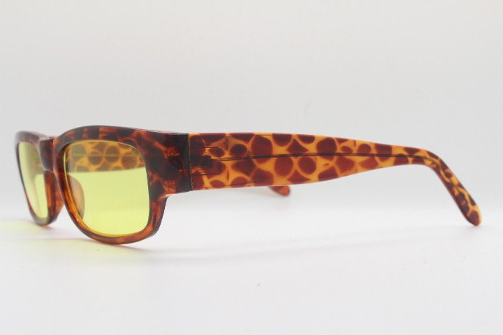 80s vintage rectangular sunglasses. Low profile 60s mod design tortoise frame with psychedelic light tone yellow lenses and fat arms. NOS