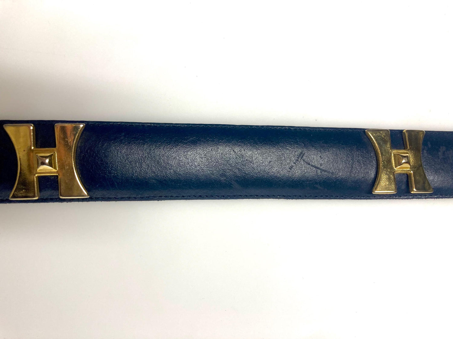 80s vintage womens dress belt in navy blue genuine leather with substantial gold chrome studded 'H' motifs. Made in France. Size S