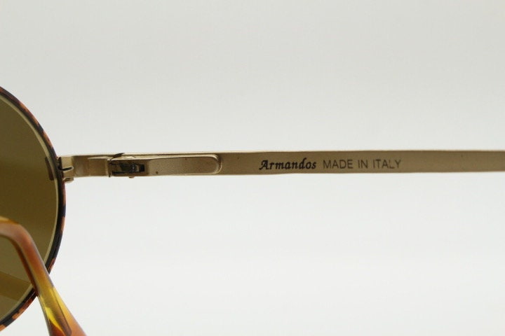 Armandos 90s vintage oval sunglasses made in Italy. Enamelled honey tortoise front with ornate tooled metal arm patterns. NOS