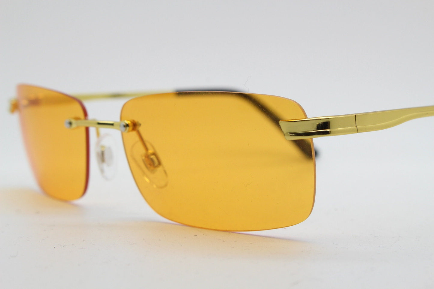 Y2K vintage frameless orange sunglasses. Rectangular lenses with gold bridge and arms. 2000s club kids. 00's. 90s Rave