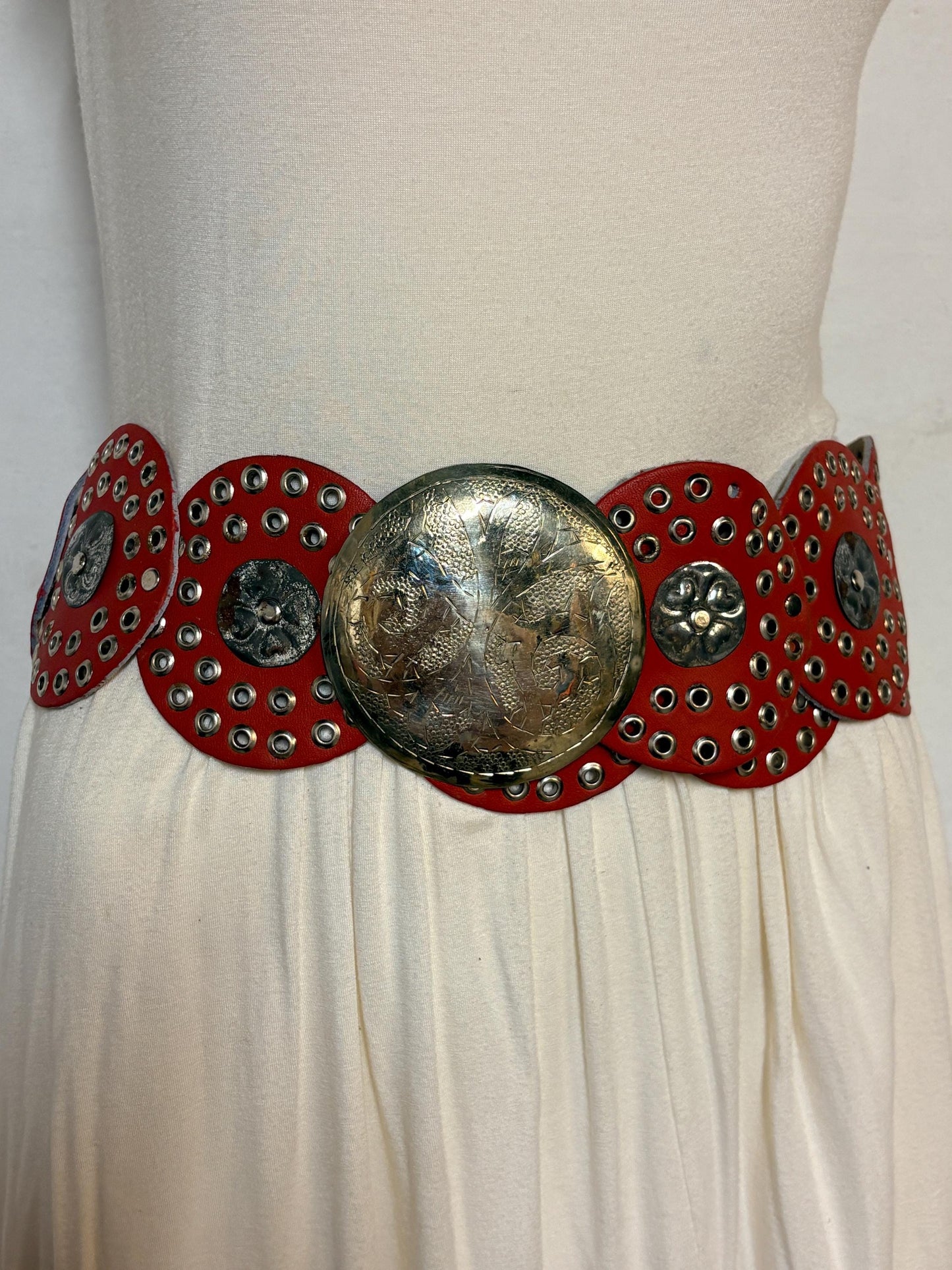 80s vintage womens huge red leather circles belt. Versatile statement piece with holed studs, metal discs and big 'shield' buckle. NOS