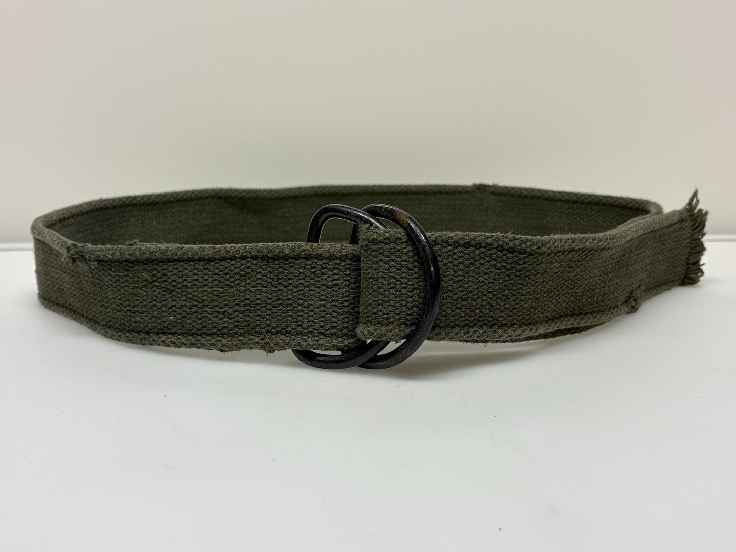 90s vintage genuine army belt. Thick woven canvas in green. Distressed look. Metal looping backwards buckle. Fully adjustable. Webbing