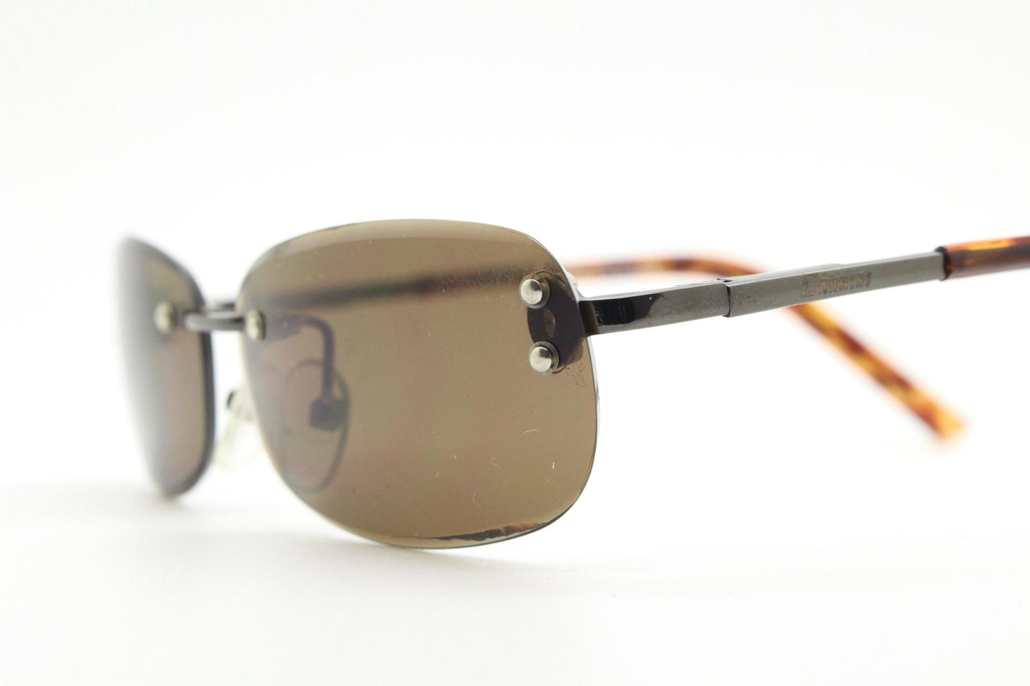 90s vintage minimal frameless sunglasses. Minimal brown rectangular lens with bevelled edges, gunmetal grey trim and tortoise arms. NOS