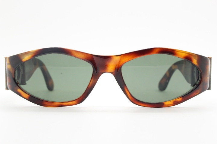 90s vintage oval sunglasses. Low profile transparent tortoise frame with massive bronze metal arm crests BNWT. Unused NOS
