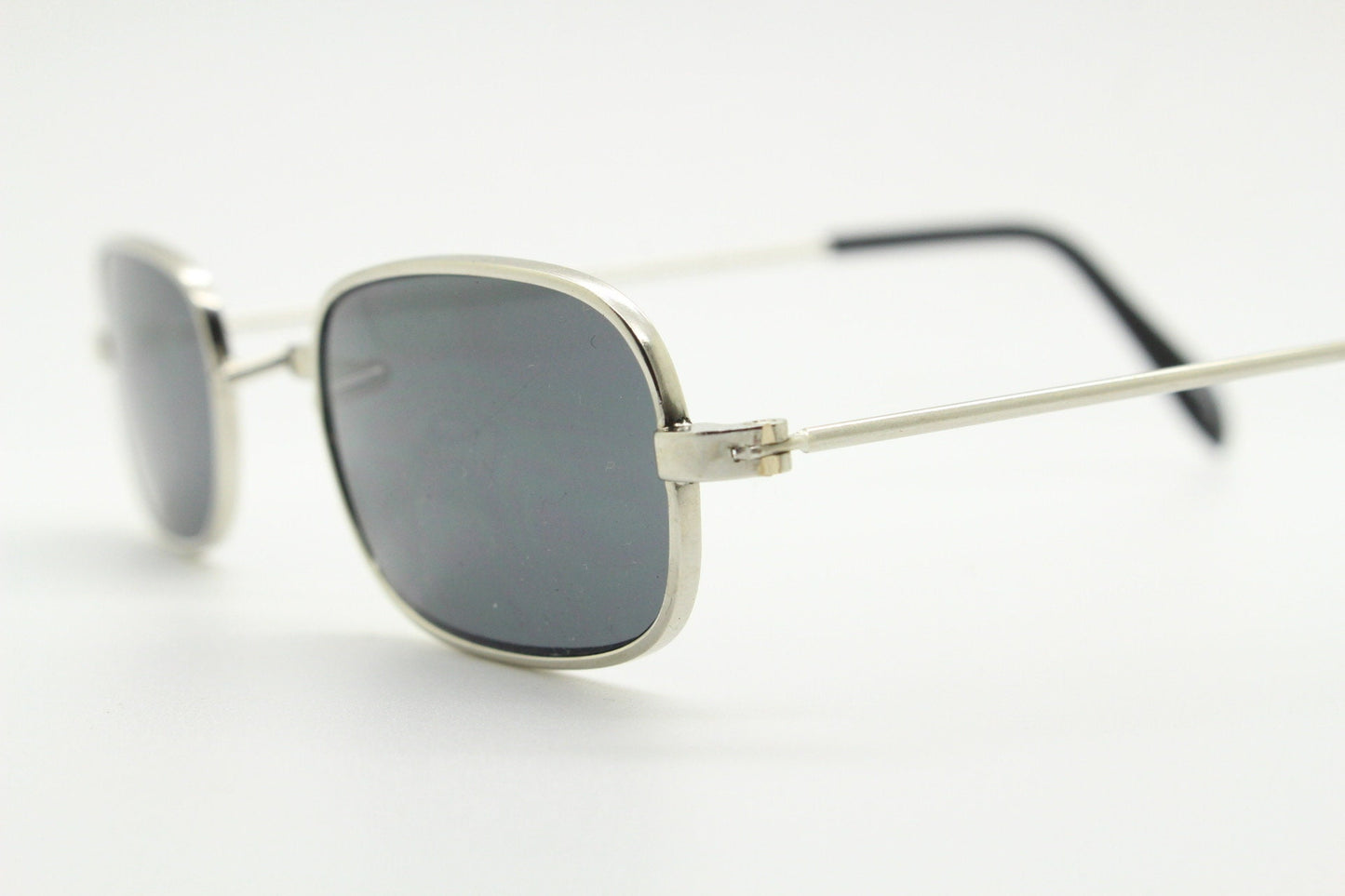 80s vintage rectangular low profile metal sunglasses. Minimal 60s mens mod design in silver chrome frame with grey lenses. NOS