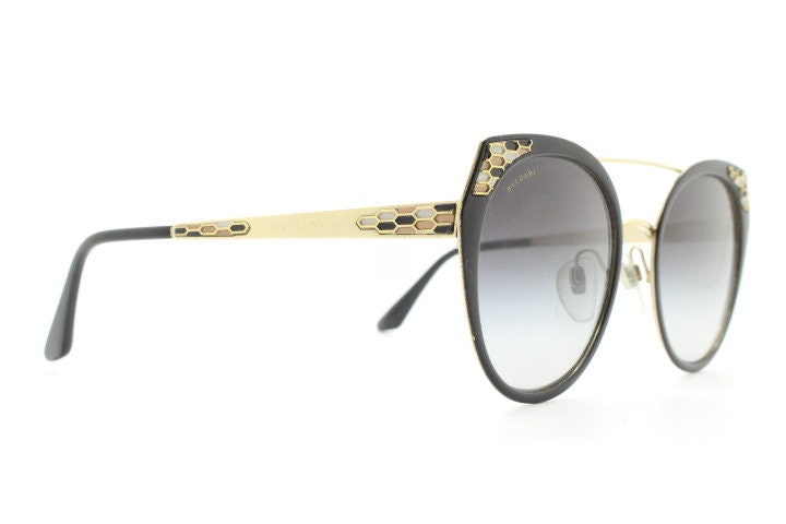 Bulgari round cropped cat eye sunglasses made in Italy. Womens black and gold frame with honeycomb patterns and smoky graduating lenses