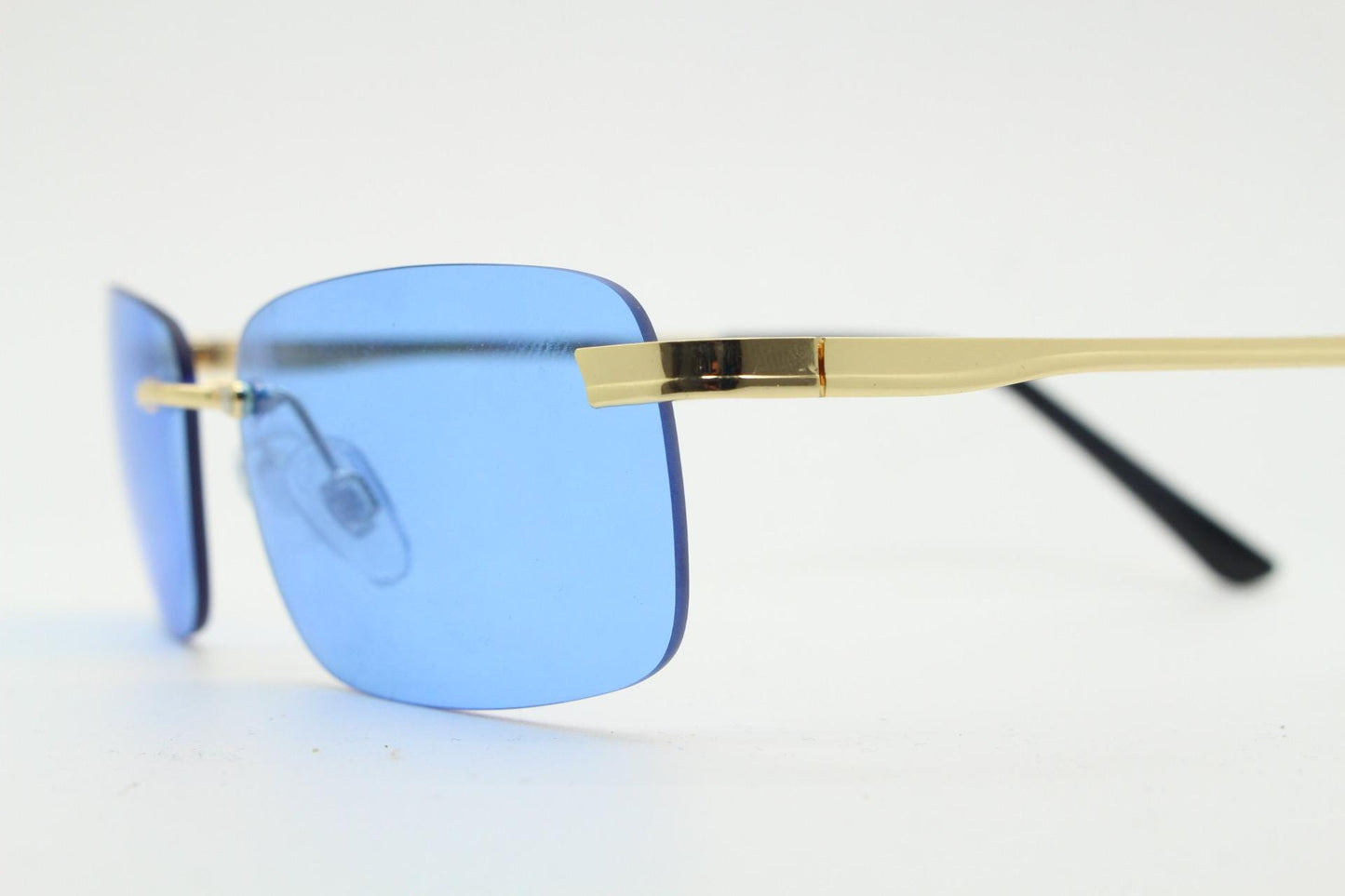 Y2K vintage frameless sky blue sunglasses. Minimalistic rectangular lenses with gold bridge and arms. 2000s club kids. 00's. 90s Rave